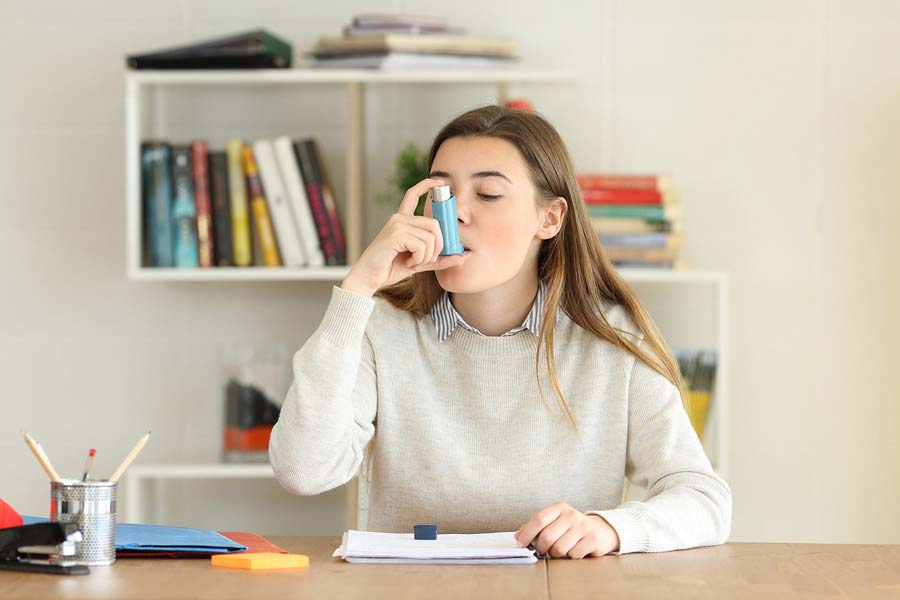 A woman with asthma using an inhaler