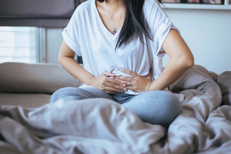 A woman dealing with abdominal pain from irritable bowel syndrome.