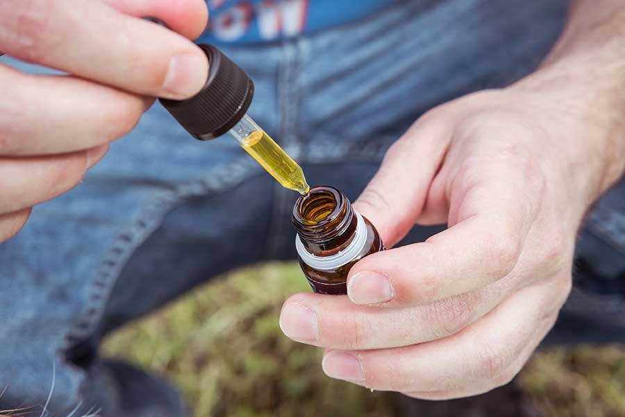 A man with CBD oil tincture for pain