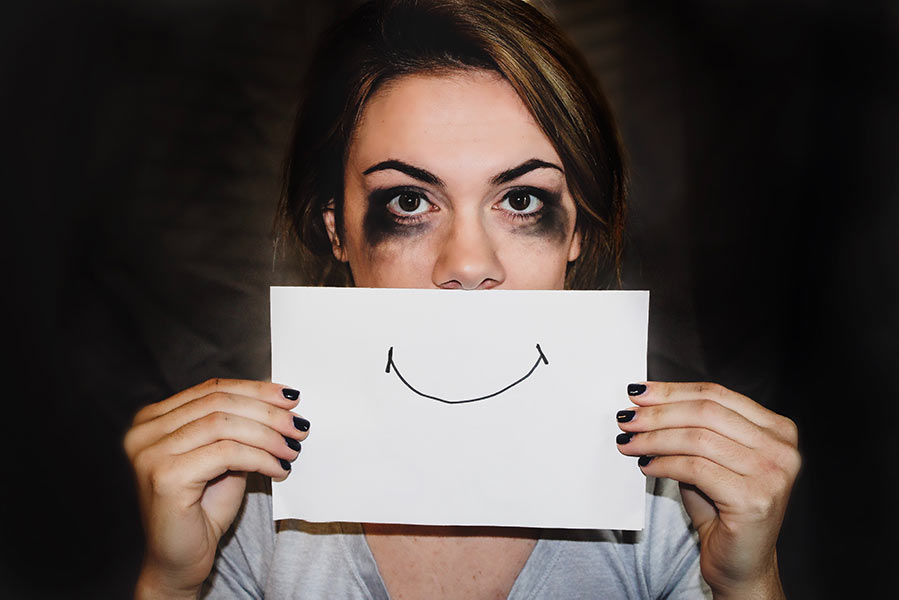 A woman hiding her depression behind smiling face