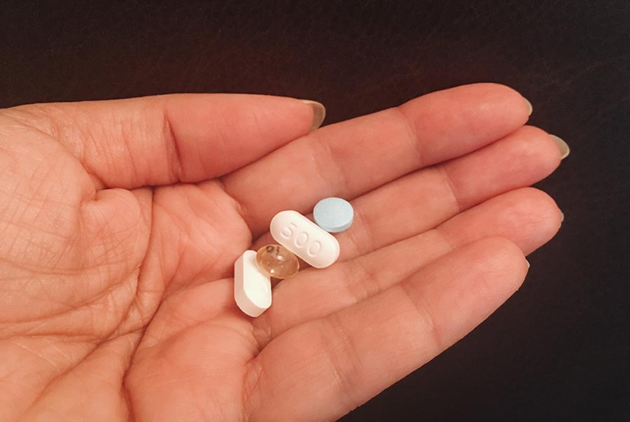 A woman holding a handful of medications