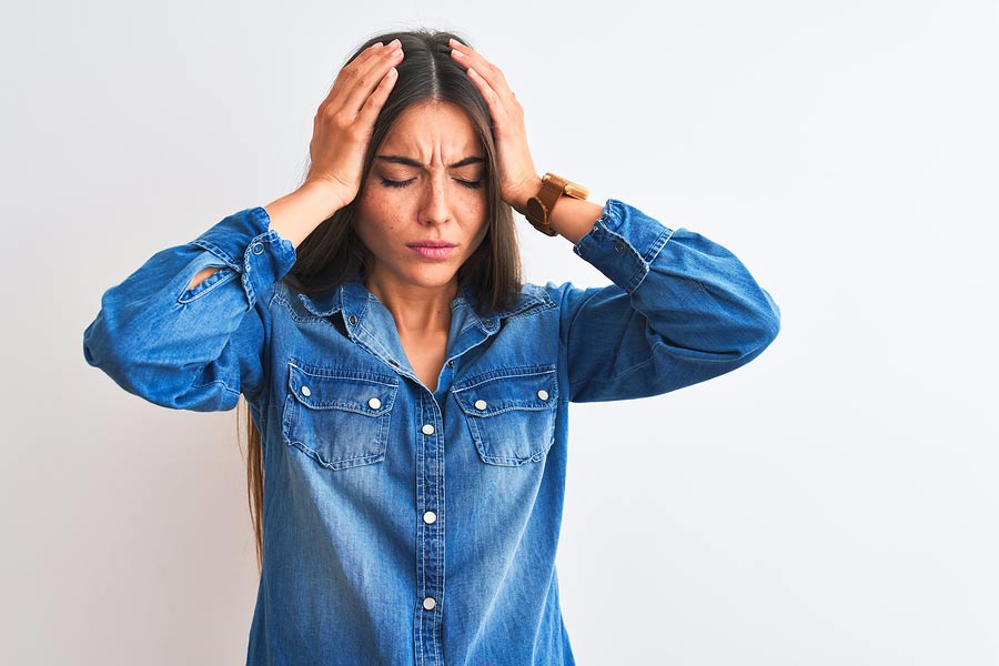 A woman holding her head from migraine pain