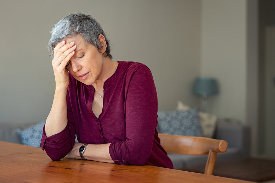 A woman holding her head suffering a migraine headache