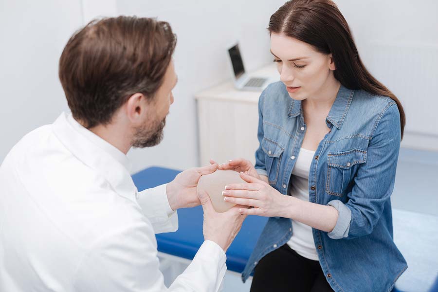 A woman with her doctor considering breast augmentation surgery after breast cancer.